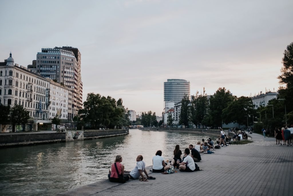 Menschen abends am Donaukanal. sitzend